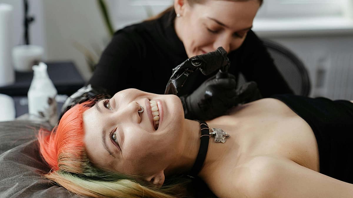 Person gently washing a fresh tattoo at a sink