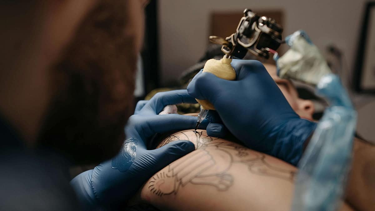 Tattoo artist layering colour during a complex cover-up