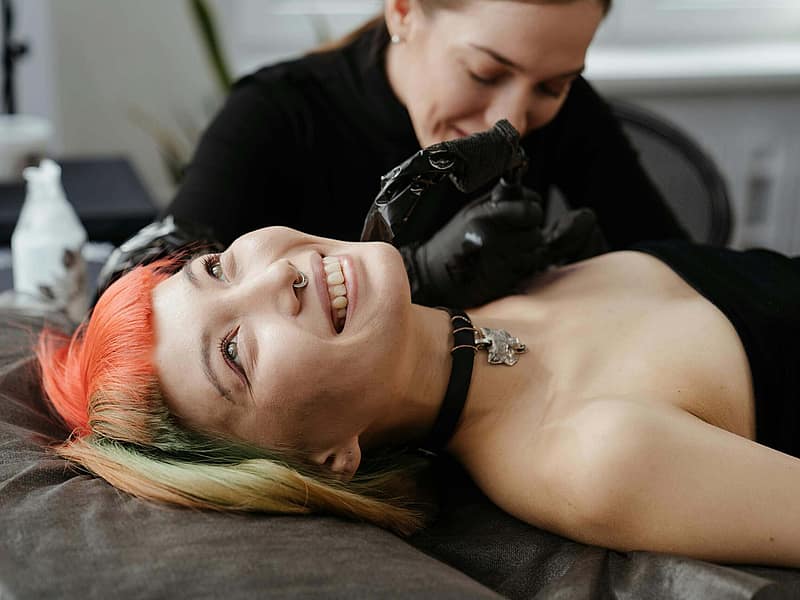 Person gently washing a fresh tattoo at a sink