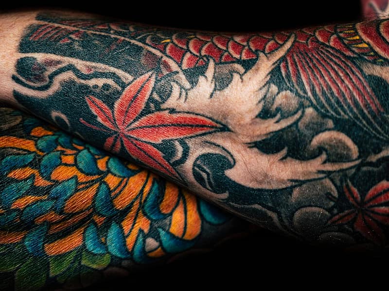Team of tattoo artists sketching together at a large table