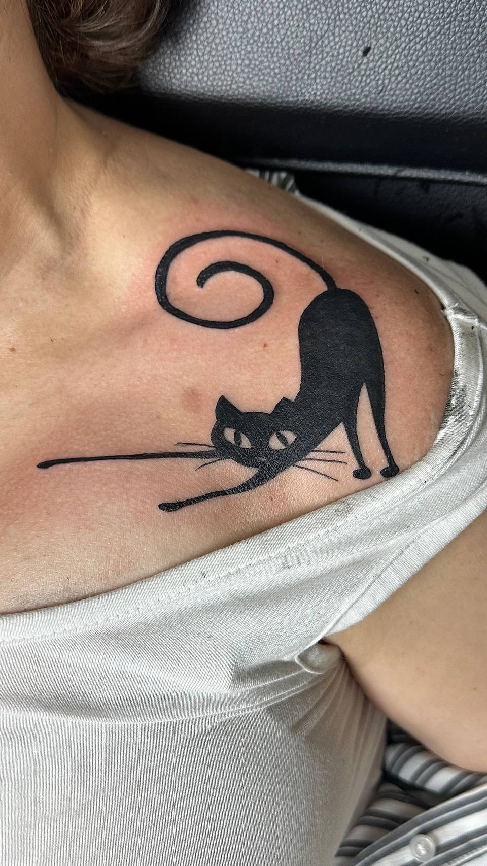 Stretching Black Cat with Curled Tail