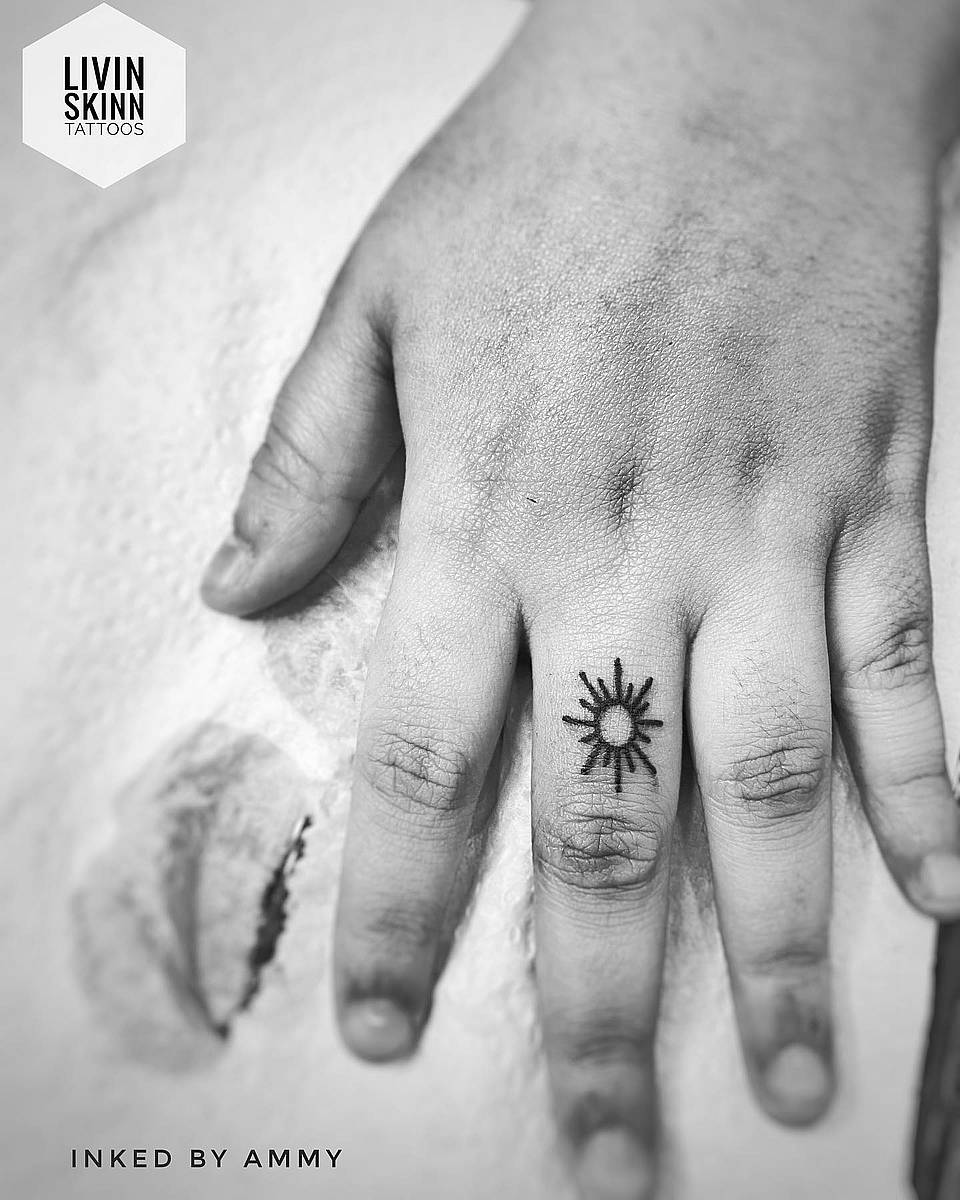 Tiny Sunburst Finger Tattoo